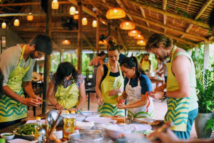 Visitors enjoying traditional culinary practices at Tra Que Vegetable Village, Hoi An