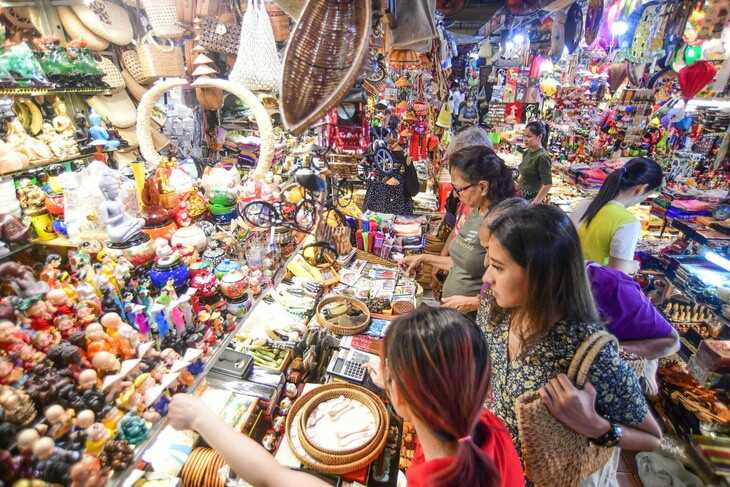 Foreign visitors buying souvenirs at Ben Thanh Market