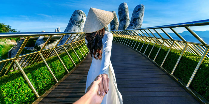 women in ao dai at golden bridge