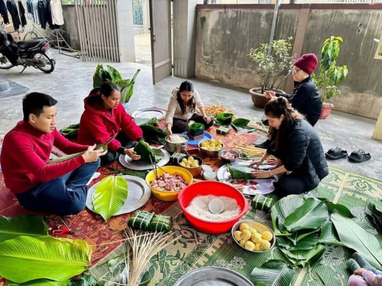 Vietnamese family members gathering and wrapping bánh chưng