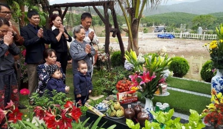 Vietnamese family visiting ancestral graves in New Year