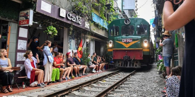 Tourists capture the passing train at Cafe 90 Đường Tàu. 