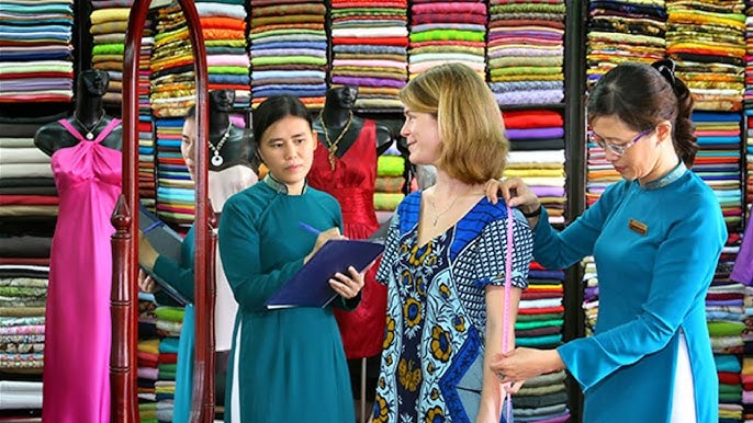 The female visitor is having her clothes measured at a shop in Hoi An