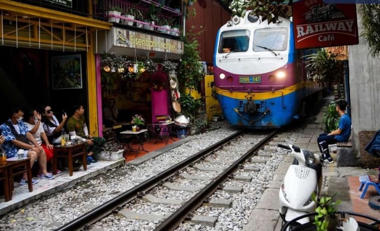 tourists capturing a passing train at Hanoi Train Street