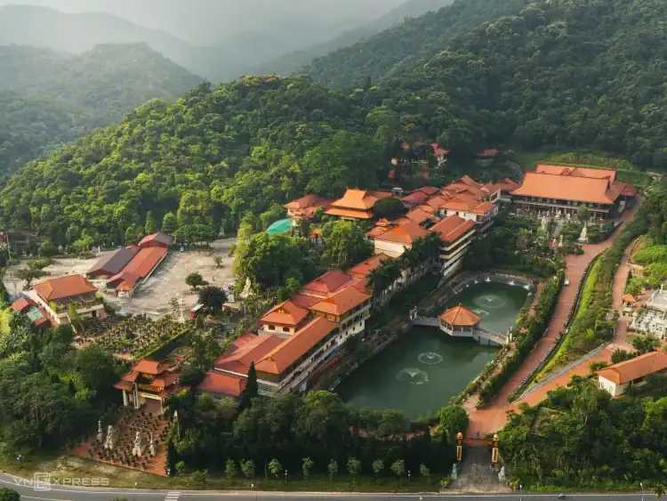 Aerial view of Lua Viet Tours complex surrounded by lush green mountains in Vietnam.