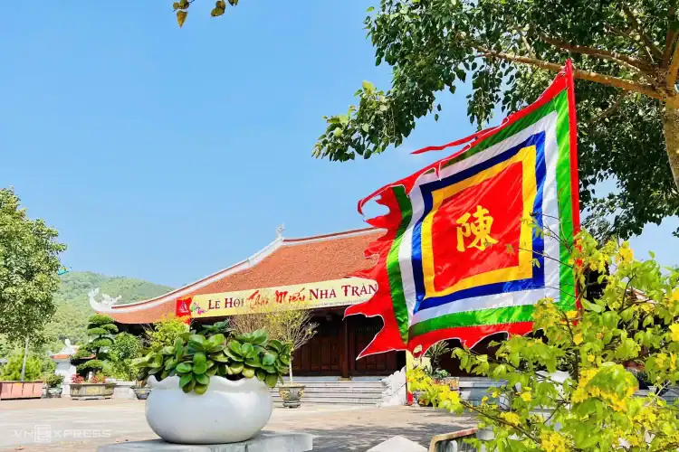 Colorful traditional Vietnamese flag flying near temple during festival in Nha Trang, Vietnam.