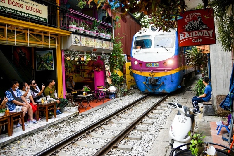 Visitors enjoying Vietnamese coffee at a trackside café on Train Street Hanoi